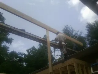 Carpenter setting a ridge beam over a new addition frame — Ice Dam Removal by Roofing Brothers in Coulter