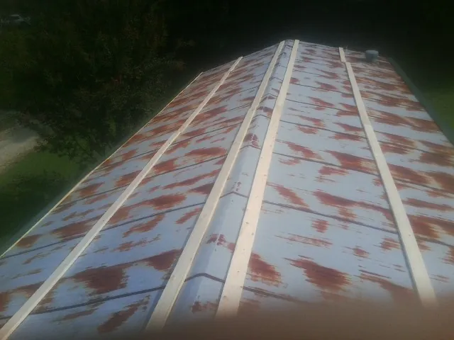 Rusted metal roof panels with new wood purlins before replacement — Storm Damage Roof Repair in Coulter by Roofing Brothers